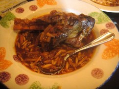 Arni Yiouvetsi (Braised Lamb Shank) -- Mediterranean herbs and savory vegetables combined to form the rich taste of an Aegean specialty, served over monastiri orzo pasta
